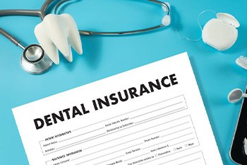 Dental insurance form next to dental instruments