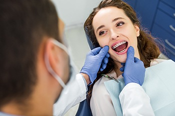 Orthodontist looking at his patient’s braces