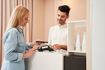 Patient paying for treatment at front desk in orthodontic office