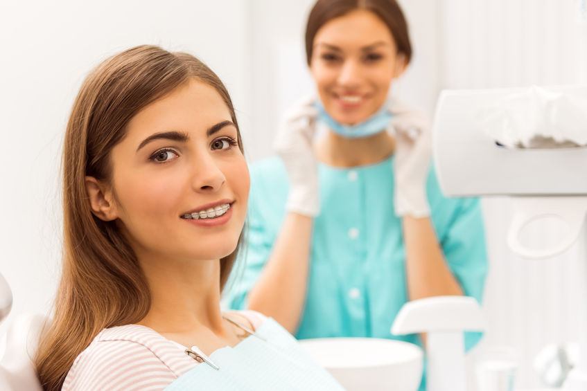 Woman in office who needs emergency orthodontist in Frisco