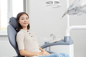 Smiling teen girl in dental treatment chair